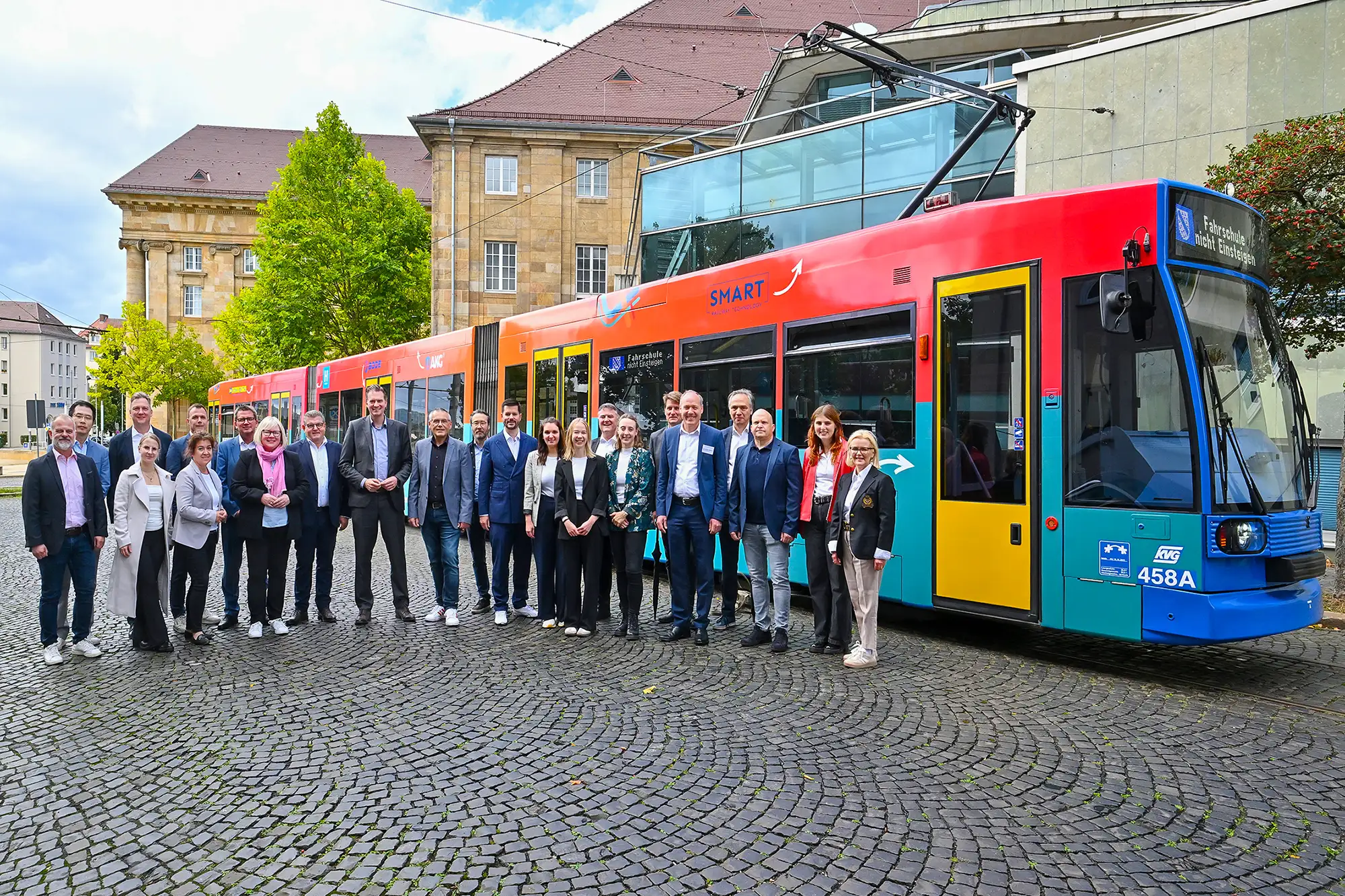 Personen stehen vor einer bedruckten Strassenbahn in Kassel