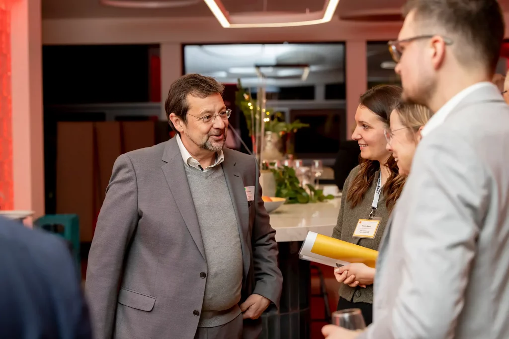 Mann redet mit mehreren Beteiligten ueber neue Projekte